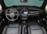 Interior del Mini Cooper S Convertible Hot Chili 2021 seminuevo con asientos de piel negros, vista completa desde atrás con capota abierta en Namacar Automotriz.