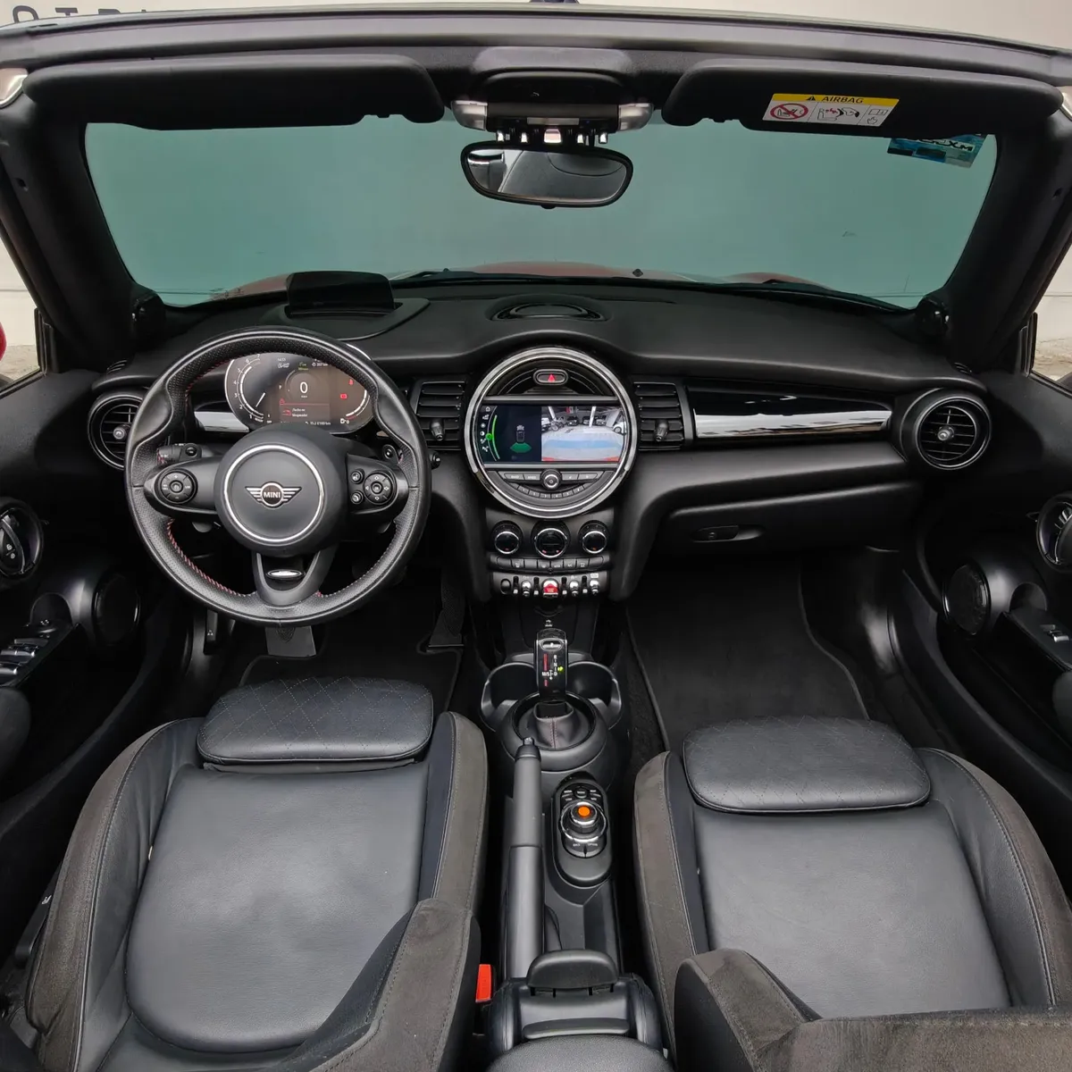 Interior del Mini Cooper S Convertible Hot Chili 2021 seminuevo con asientos de piel negros, vista completa desde atrás con capota abierta en Namacar Automotriz.