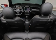 Vista aérea interior desde la parte trasera de un Mini Cooper S Convertible Hot Chili 2021 seminuevo con asientos traseros de piel negros en Namacar Automotriz.