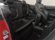 Vista lateral izquierda trasera de la segunda fila de asientos de piel negros en un Mini Cooper S Convertible Hot Chili 2021 seminuevo con capota abierta en Namacar Automotriz.