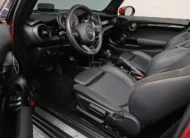 Vista lateral izquierda detallada de los asientos traseros de piel negros en un Mini Cooper S Convertible Hot Chili 2021 seminuevo con capota abierta en Namacar Automotriz.