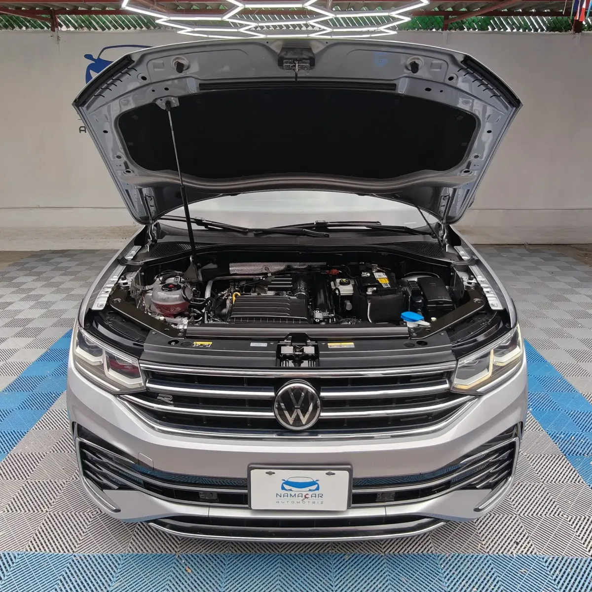 Vista frontal superior en picada del compartimiento del motor 1.4L Turbo TSI de una SUV Volkswagen Tiguan R-Line 2022 seminueva con el cofre abierto en las instalaciones de Namacar Automotriz.