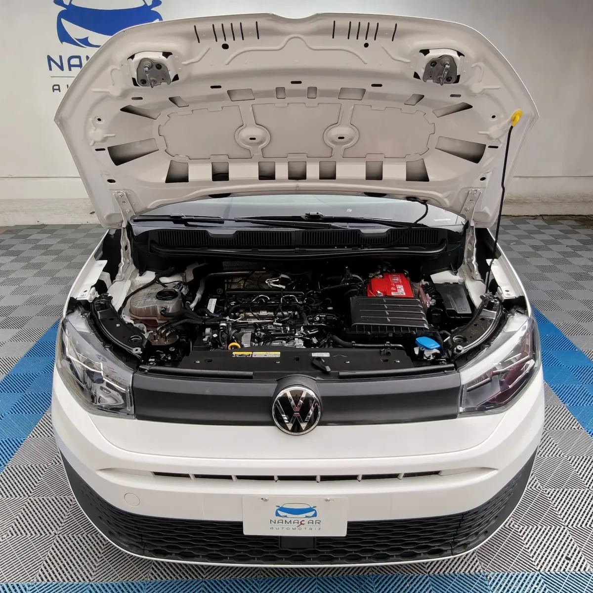 Vista frontal superior en picada del motor 2.0 litros diésel de una van Volkswagen Caddy Maxi TDI 2022 seminueva con el cofre abierto en Namacar Automotriz.