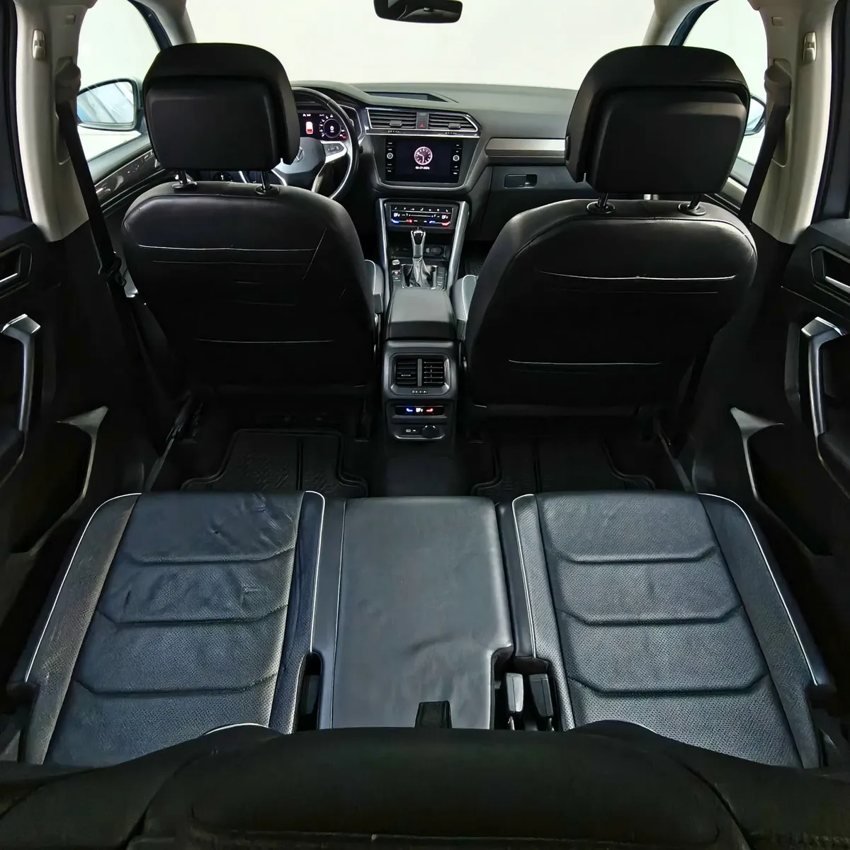 Vista interior en perspectiva cenital desde la cajuela que muestra la segunda fila de asientos en piel y el tablero delantero completo de una SUV Volkswagen Tiguan 1.4 R-Line 2022 seminueva en Namacar Automotriz.