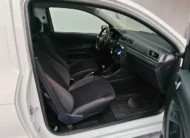 Vista interior desde la puerta del copiloto abierta que muestra los asientos de tela oscuros, el tablero y el volante de una camioneta pick-up Volkswagen Saveiro 1.6 Robust MT año 2025 seminueva en ángulo oblicuo derecho.