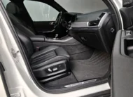 Vista interior desde la puerta del copiloto abierta que muestra el asiento de piel del pasajero delantero, los tapetes texturizados y el tablero de una SUV de lujo BMW X5 2021 seminueva en ángulo oblicuo derecho.
