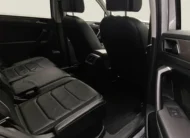 Vista interior desde la puerta trasera derecha abierta que muestra la segunda fila de asientos en piel, el espacio posterior para pasajeros y el techo panorámico de una SUV Volkswagen Tiguan 1.4 R-Line 2022 seminueva en ángulo oblicuo derecho.