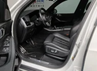 Vista interior desde la puerta del conductor abierta que muestra el asiento de piel del piloto, el volante multifunción y el tablero de una SUV de lujo BMW X5 2021 seminueva en ángulo oblicuo izquierdo.