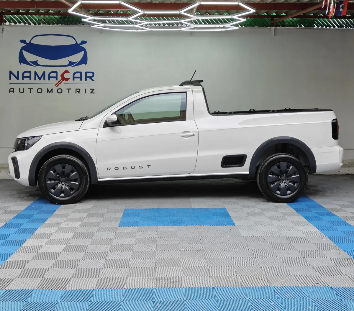 Camioneta pick-up compacta Volkswagen Saveiro 1.6 Robust MT año 2025 seminueva en color blanco, vista exterior de perfil lateral izquierdo completo en las instalaciones de Namacar Automotriz.