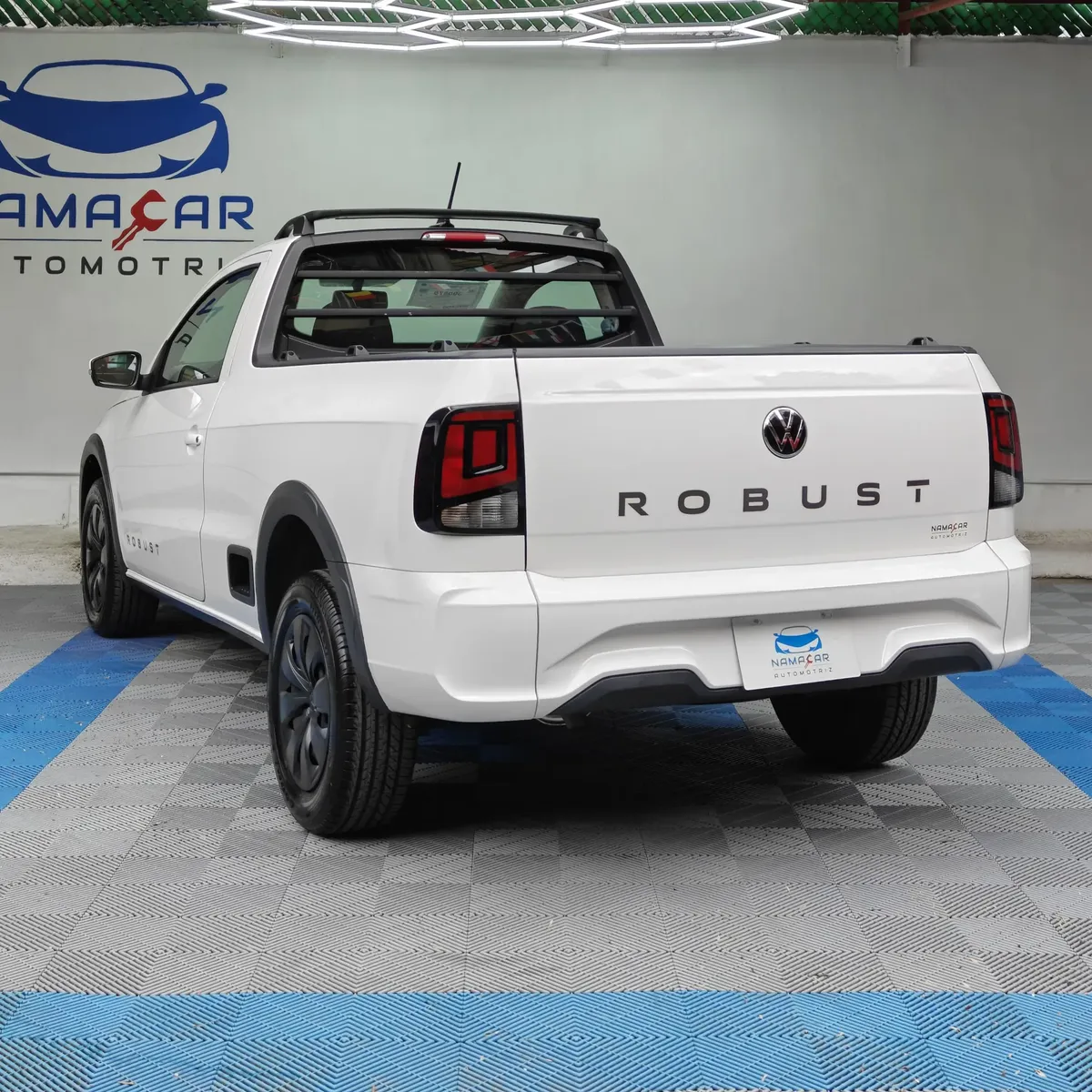 Camioneta pick-up Volkswagen Saveiro 1.6 Robust MT año 2025 seminueva en color blanco, vista exterior trasera en ángulo de tres cuartos izquierda exhibida en Namacar Automotriz.