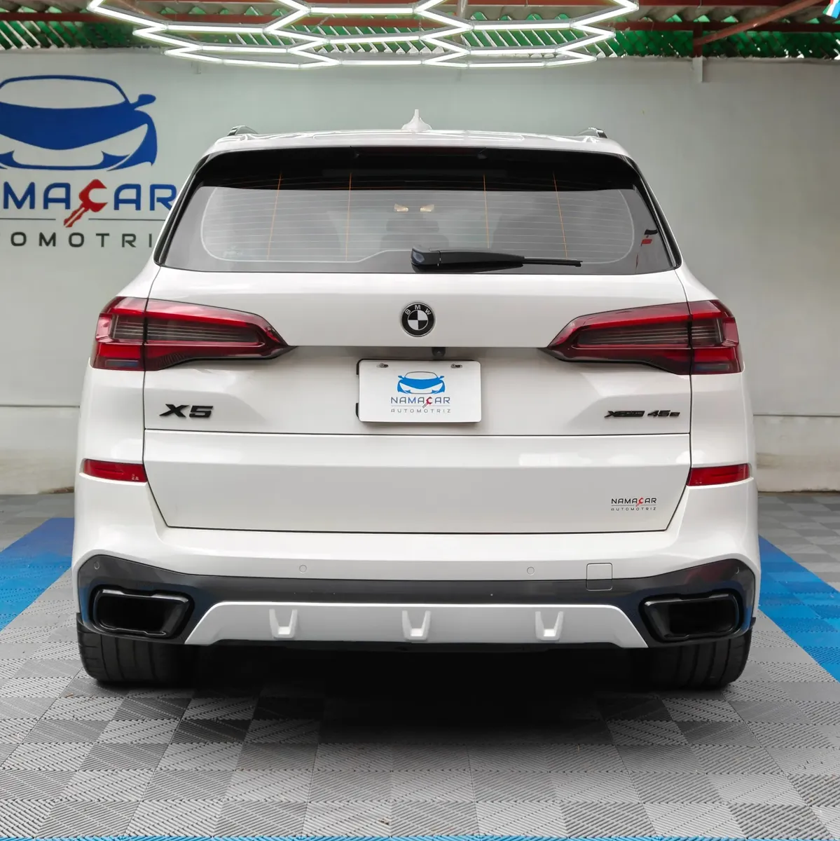 SUV híbrida de lujo BMW X5 2021 seminueva en color blanco, vista exterior trasera directa y completa exhibida en Namacar Automotriz.