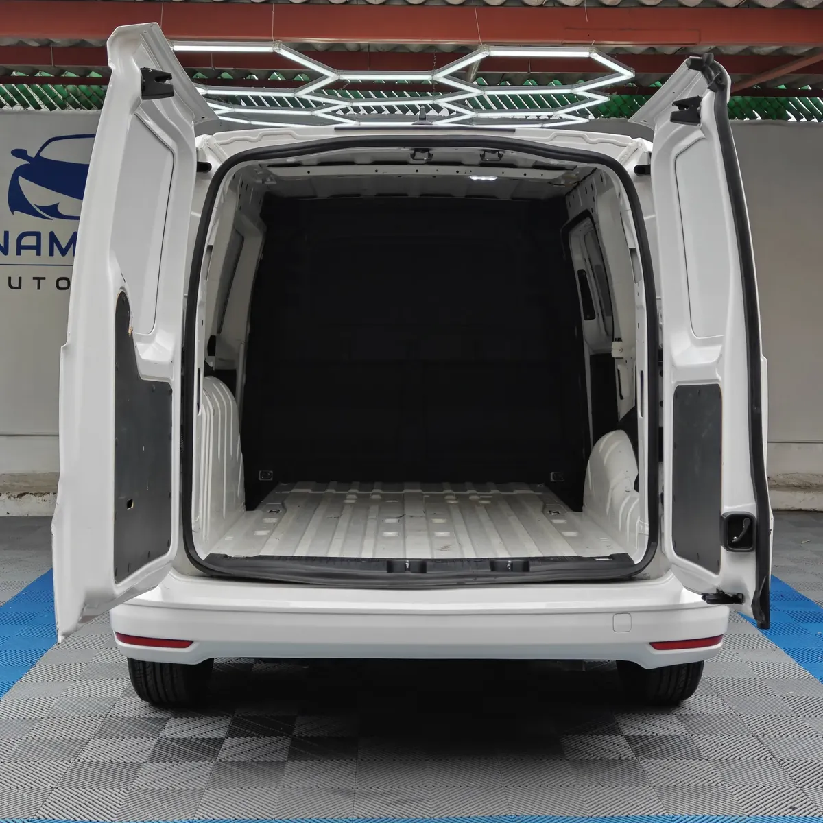 Vista trasera directa con las puertas abiertas, mostrando el amplio espacio interior de carga panel de una van Volkswagen Caddy 2.0 Maxi TDI MT 2022 seminueva en Namacar Automotriz.