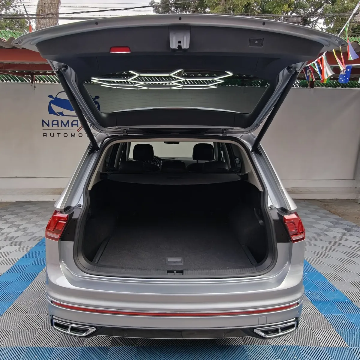 Vista trasera directa con la cajuela abierta, mostrando el amplio espacio de carga posterior y el cubreobjetos de una SUV Volkswagen Tiguan 1.4 R-Line 2022 seminueva en Namacar Automotriz.