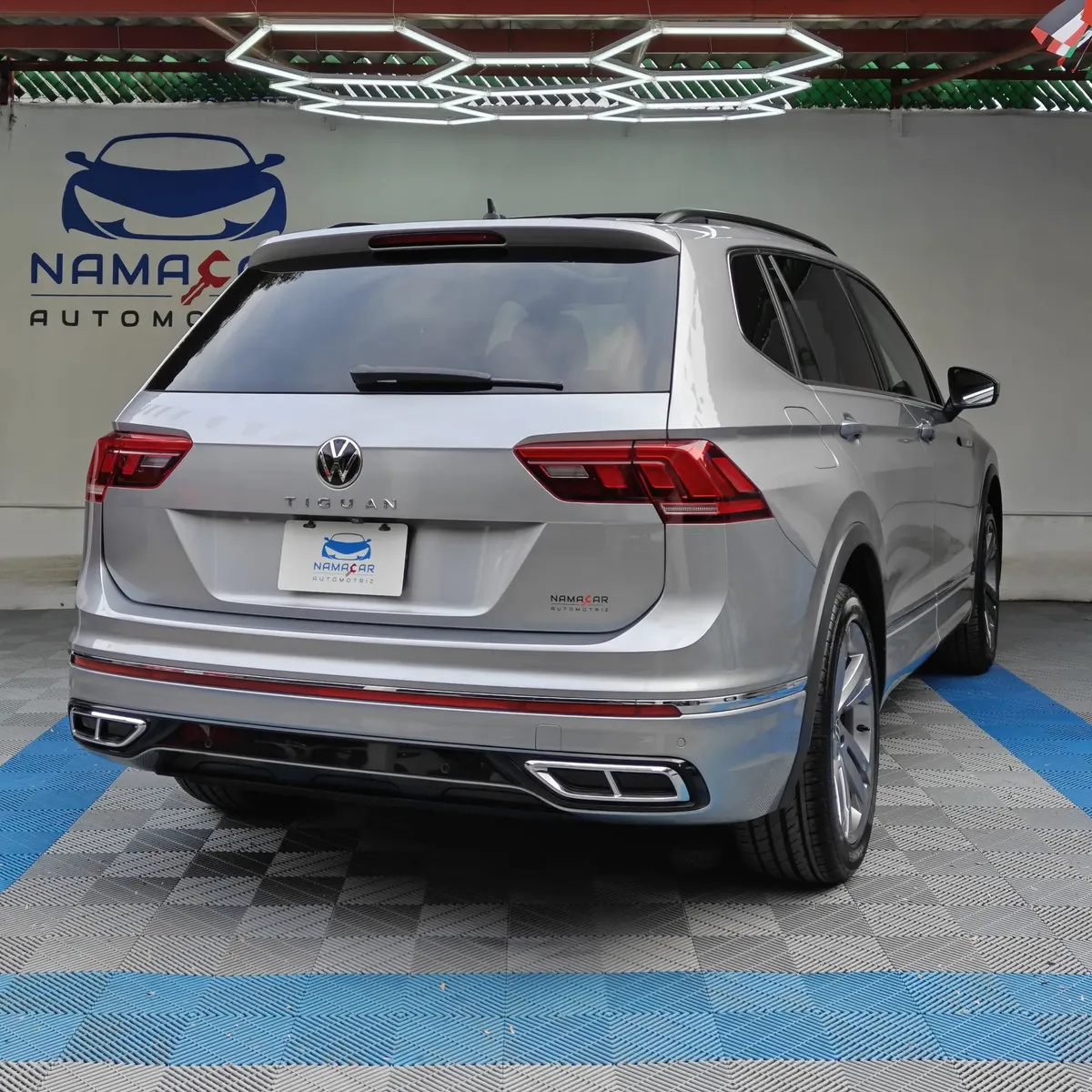 SUV familiar Volkswagen Tiguan 1.4 R-Line 2022 seminueva en color plata, vista exterior trasera en ángulo de tres cuartos derecha exhibida en Namacar Automotriz.