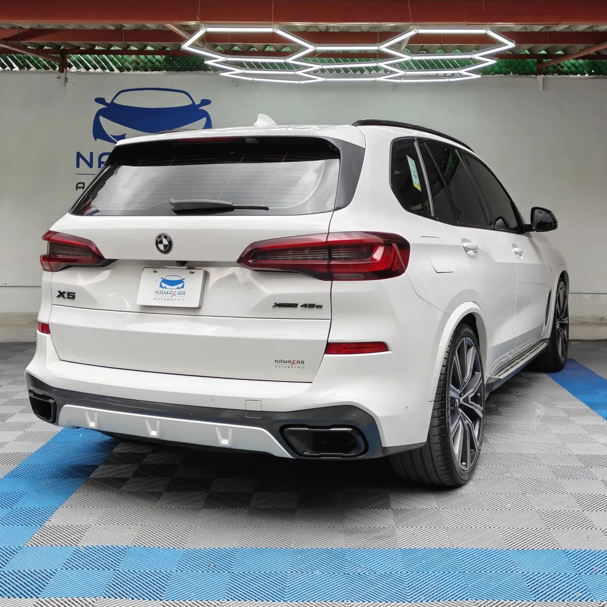 SUV de lujo BMW X5 2021 seminueva en color blanco, vista exterior trasera en ángulo de tres cuartos derecha exhibida en las instalaciones de Namacar Automotriz.