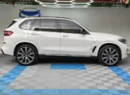 SUV premium BMW X5 2021 seminueva en color blanco, vista exterior de perfil lateral derecho completo en el área de exhibición de Namacar Automotriz.