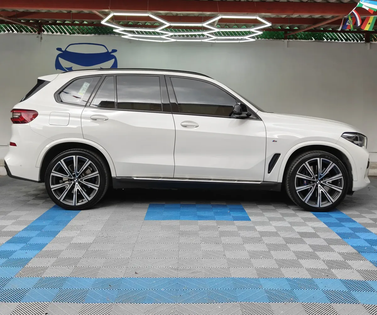 SUV premium BMW X5 2021 seminueva en color blanco, vista exterior de perfil lateral derecho completo en el área de exhibición de Namacar Automotriz.