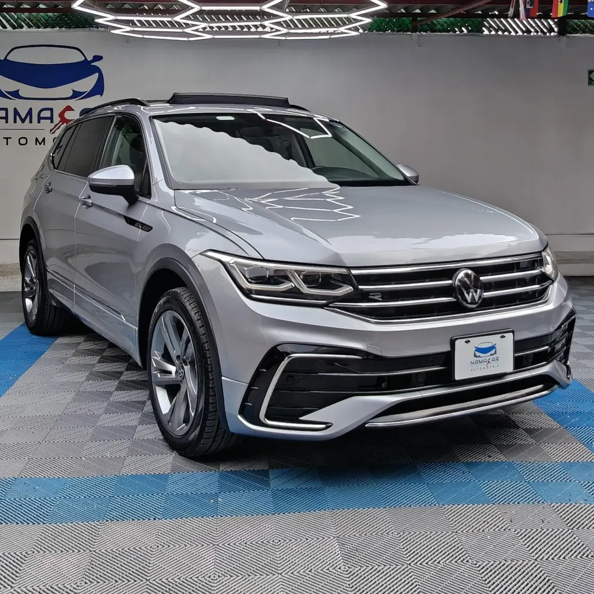 SUV deportiva Volkswagen Tiguan 1.4 R-Line 2022 seminueva en color plata, vista exterior frontal en ángulo de tres cuartos derecha expuesta en Namacar Automotriz.