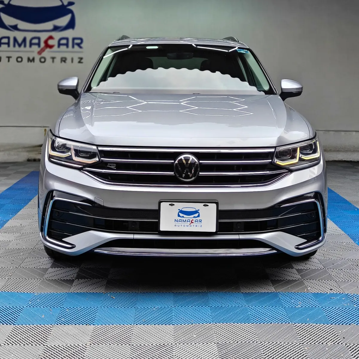 SUV deportiva Volkswagen Tiguan 1.4 R-Line 2022 seminueva en color plata, vista exterior frontal directa y completa exhibida en las instalaciones de Namacar Automotriz.