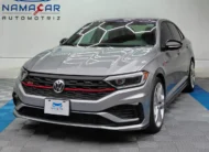 Auto sedán deportivo Volkswagen Jetta 2.0 GLI DSG automático año 2021 seminuevo en color gris plata, vista exterior frontal en ángulo de tres cuartos izquierda exhibido en Namacar Automotriz.
