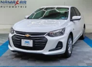 Auto sedán subcompacto Chevrolet Onix 1.3 LS manual año 2024 seminuevo en color blanco, vista exterior frontal en ángulo de tres cuartos izquierda exhibido en Namacar Automotriz.
