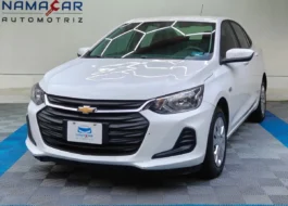 Auto sedán subcompacto Chevrolet Onix 1.3 LS manual año 2024 seminuevo en color blanco, vista exterior frontal en ángulo de tres cuartos izquierda exhibido en Namacar Automotriz.