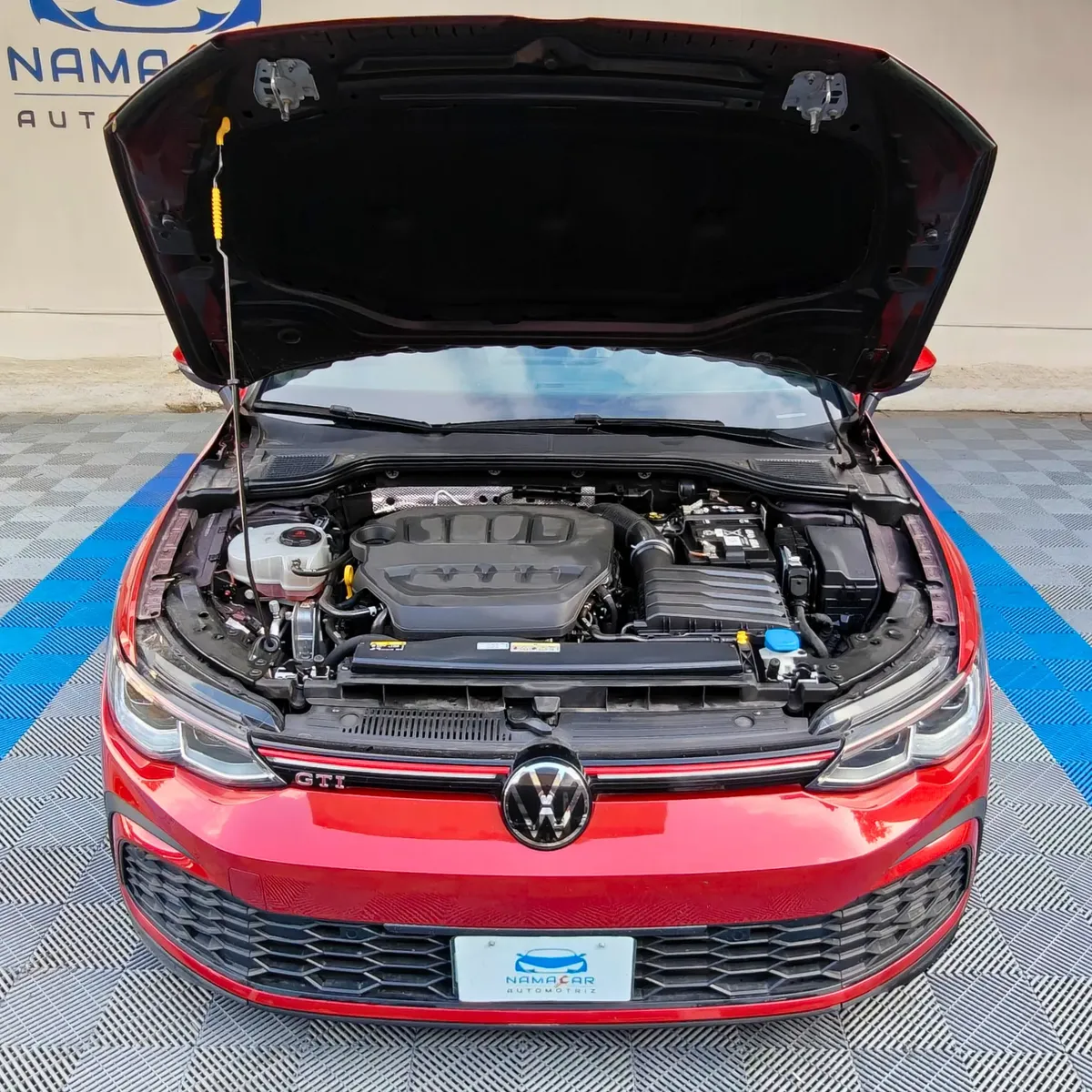 Hatchback deportivo Volkswagen Golf GTI 2.0 L de 241 HP automático DSG7 año 2024 seminuevo en color rojo brillante, vista exterior delantera con el cofre abierto mostrando el compartimento del motor exhibido en Namacar Automotriz.