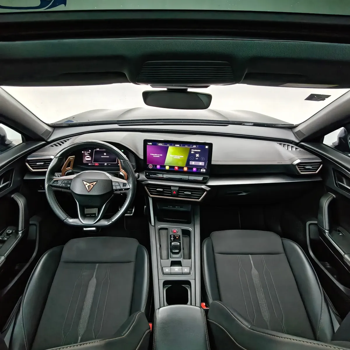 Vista interior cenital desde arriba que muestra la cabina, el tablero con pantalla táctil, el volante deportivo con logotipo cobre, la consola central y los asientos delanteros tipo balde de una SUV Crossover deportiva Cupra Formentor 2.0 Mid 190 HP 2WD DSG7 año 2022 seminueva.