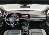 Vista interior desde los asientos traseros hacia el frente que muestra el tablero Digital Cockpit, la pantalla de infoentretenimiento, el volante deportivo, la consola central y los asientos delanteros de un hatchback deportivo Volkswagen Golf GTI 2.0 241 HP DSG7 año 2024 seminuevo.