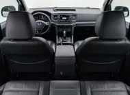 Vista interior desde la banca trasera hacia adelante que muestra los respaldos delanteros, la consola central, el tablero y el parabrisas de una camioneta pickup Volkswagen Amarok 2.0 Highline 4Motion automática año 2018 seminueva.
