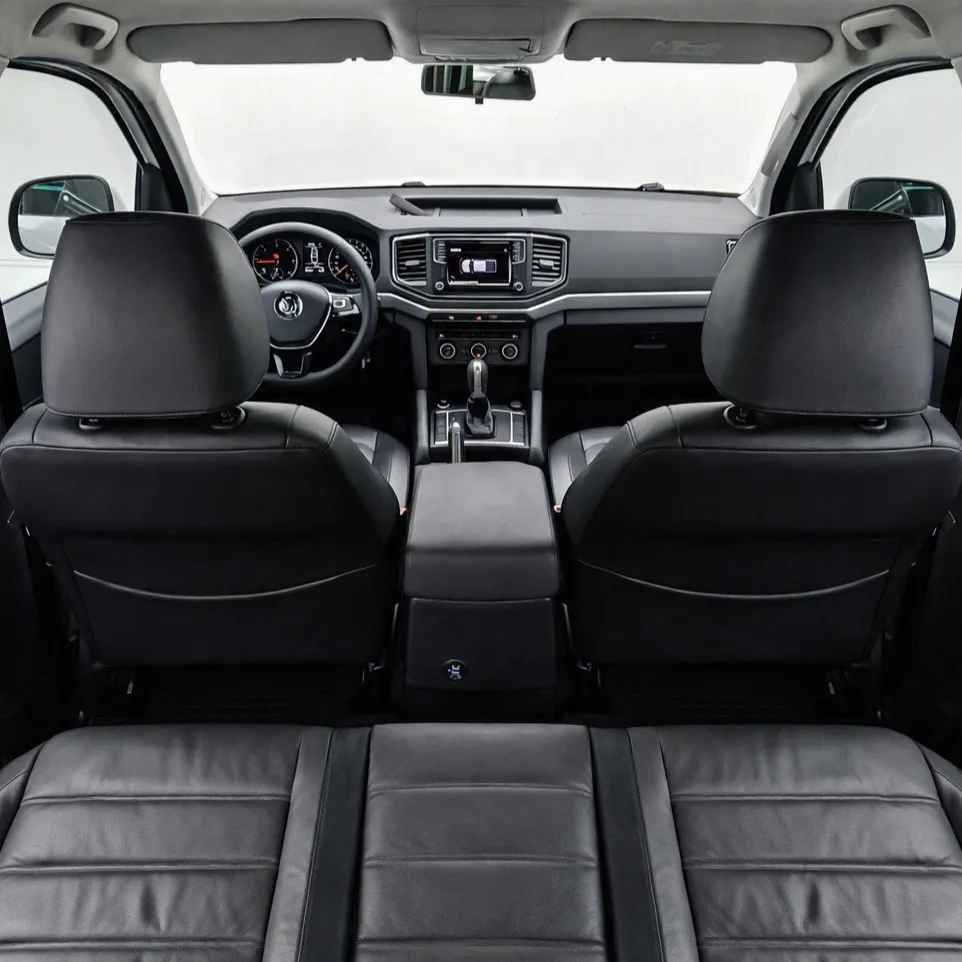Vista interior desde la banca trasera hacia adelante que muestra los respaldos delanteros, la consola central, el tablero y el parabrisas de una camioneta pickup Volkswagen Amarok 2.0 Highline 4Motion automática año 2018 seminueva.