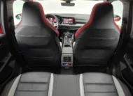 Vista interior desde la banca posterior mirando hacia el frente que muestra el respaldo de los asientos delanteros tipo bucket con acentos rojos, la consola central trasera con salidas de aire y el tablero de un hatchback deportivo Volkswagen Golf GTI 2.0 241 HP DSG7 año 2024 seminuevo.