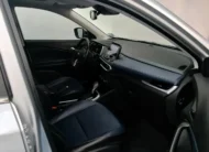 Vista interior desde la puerta del copiloto abierta que muestra el asiento delantero derecho forrado en piel bitono azul y negro, el tablero con acabados en piel, la pantalla de infoentretenimiento y la consola central de una camioneta SUV Chevrolet Tracker 1.2 Premier Turbo transmisión automática año 2023 seminueva en ángulo oblicuo derecho.