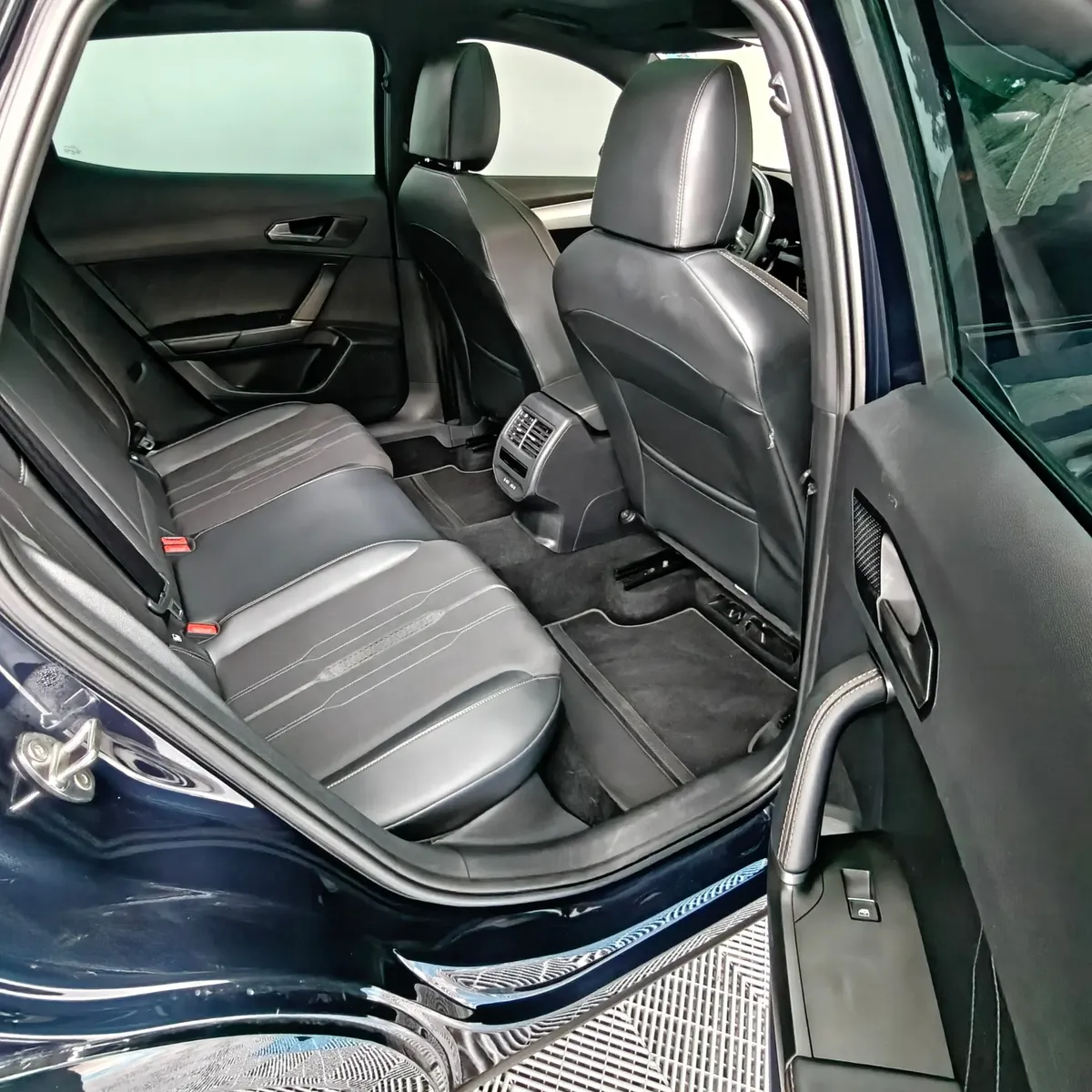 Vista interior desde la puerta trasera derecha abierta que muestra la banca de asientos posteriores tapizados en piel y tela, el espacio para piernas y las salidas de aire acondicionado traseras de una SUV Crossover deportiva Cupra Formentor 2.0 Mid 190 HP 2WD DSG7 año 2022 seminueva en ángulo oblicuo derecho.
