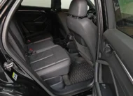 Vista interior desde la puerta trasera derecha abierta que muestra la banca de asientos posteriores tapizados en piel negra con costuras rojas, las salidas de aire acondicionado traseras y el piso de alfombra con tapetes de uso rudo de una camioneta SUV Audi Q3 2.0 S Line 180 Hp transmisión DSG automática año 2022 seminueva en ángulo oblicuo derecho.