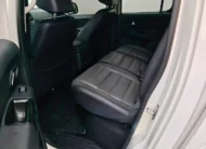 Vista interior desde la puerta trasera izquierda abierta que muestra la banca de asientos posteriores tapizados en piel negra y la zona de pasajeros de una camioneta pickup Volkswagen Amarok 2.0 Highline 4Motion automática año 2018 seminueva en ángulo oblicuo izquierdo.