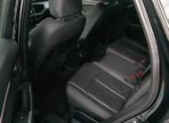 Vista interior desde la puerta trasera izquierda abierta que expone la banca de asientos posteriores tapizados en piel negra con costuras en rojo, los cinturones de seguridad de tres puntos y el espacio para piernas de una camioneta SUV Audi Q3 2.0 S Line 180 Hp transmisión DSG automática año 2022 seminueva en ángulo oblicuo izquierdo.