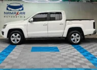 Camioneta pickup Volkswagen Amarok 2.0 Highline 4Motion automática año 2018 seminueva en color blanco, vista exterior de perfil lateral izquierdo completo exhibida en Namacar Automotriz.
