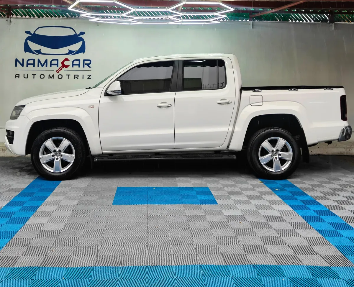 Camioneta pickup Volkswagen Amarok 2.0 Highline 4Motion automática año 2018 seminueva en color blanco, vista exterior de perfil lateral izquierdo completo exhibida en Namacar Automotriz.