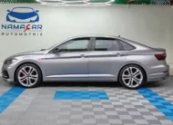 Auto sedán deportivo Volkswagen Jetta 2.0 GLI DSG automático año 2021 seminuevo en color gris plata, vista exterior de perfil lateral izquierdo completo exhibido en Namacar Automotriz.