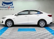 Auto sedán Chevrolet Onix 1.3 LS manual año 2024 seminuevo en color blanco, vista exterior lateral perfil izquierdo completo exhibido en Namacar Automotriz.