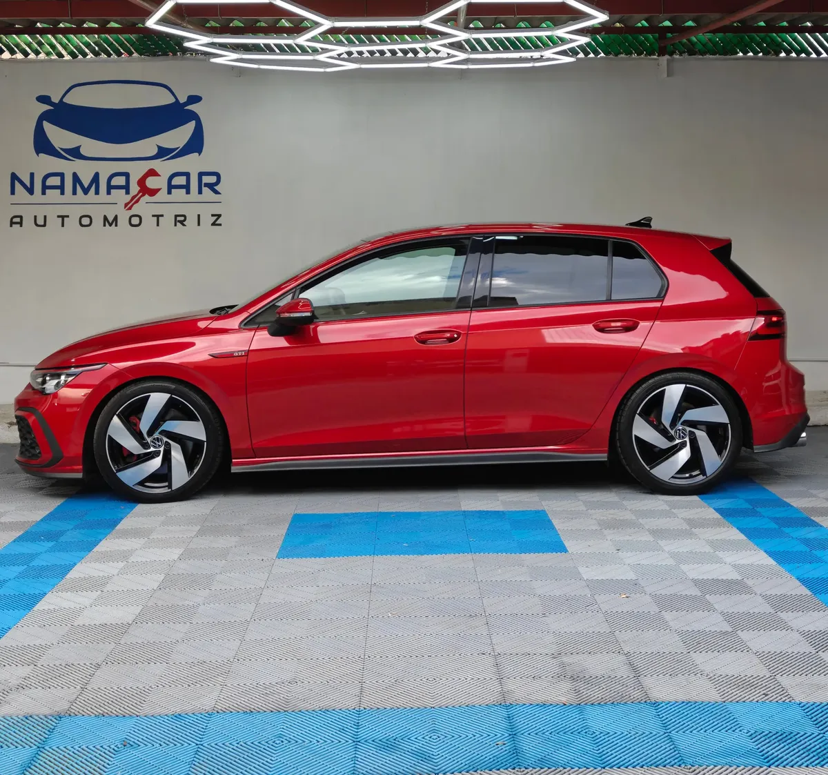 Hatchback deportivo Volkswagen Golf GTI 2.0 L de 241 HP automático DSG7 año 2024 seminuevo en color rojo brillante, vista exterior lateral perfil izquierdo completo exhibido en Namacar Automotriz.