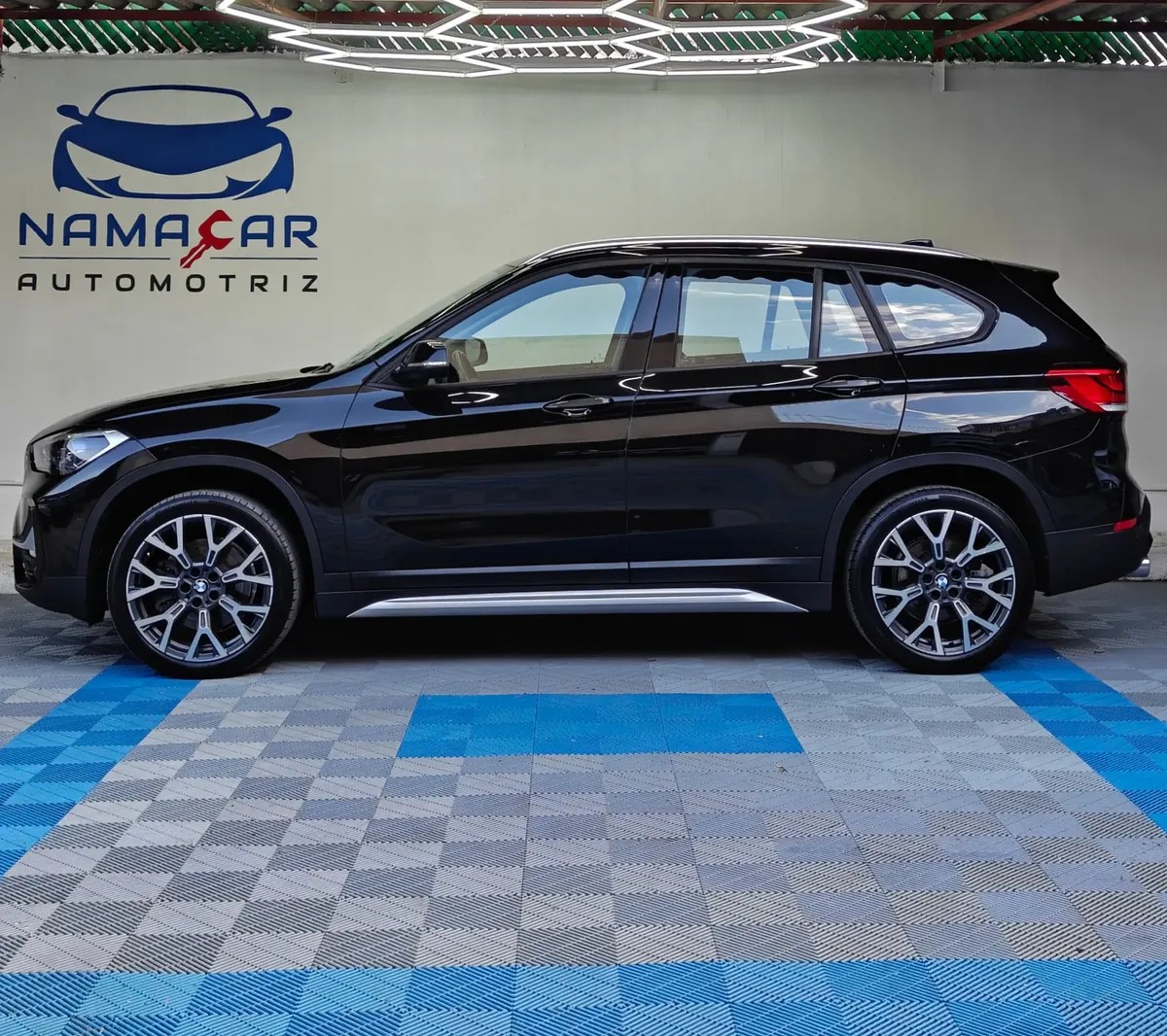 Camioneta SUV de lujo BMW X1 2.0 sDrive20i sDrive 20iA X Line transmisión automática año 2022 seminueva en color negro, vista exterior lateral perfil izquierdo completo exhibida en Namacar Automotriz.