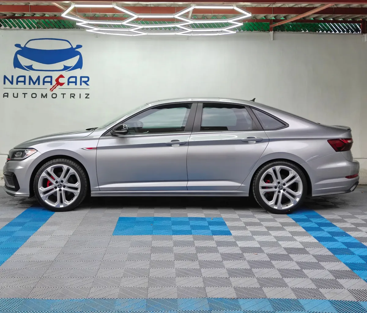 Auto sedán deportivo Volkswagen Jetta 2.0 GLI DSG automático año 2021 seminuevo en color gris plata, vista exterior de perfil lateral izquierdo completo exhibido en Namacar Automotriz.