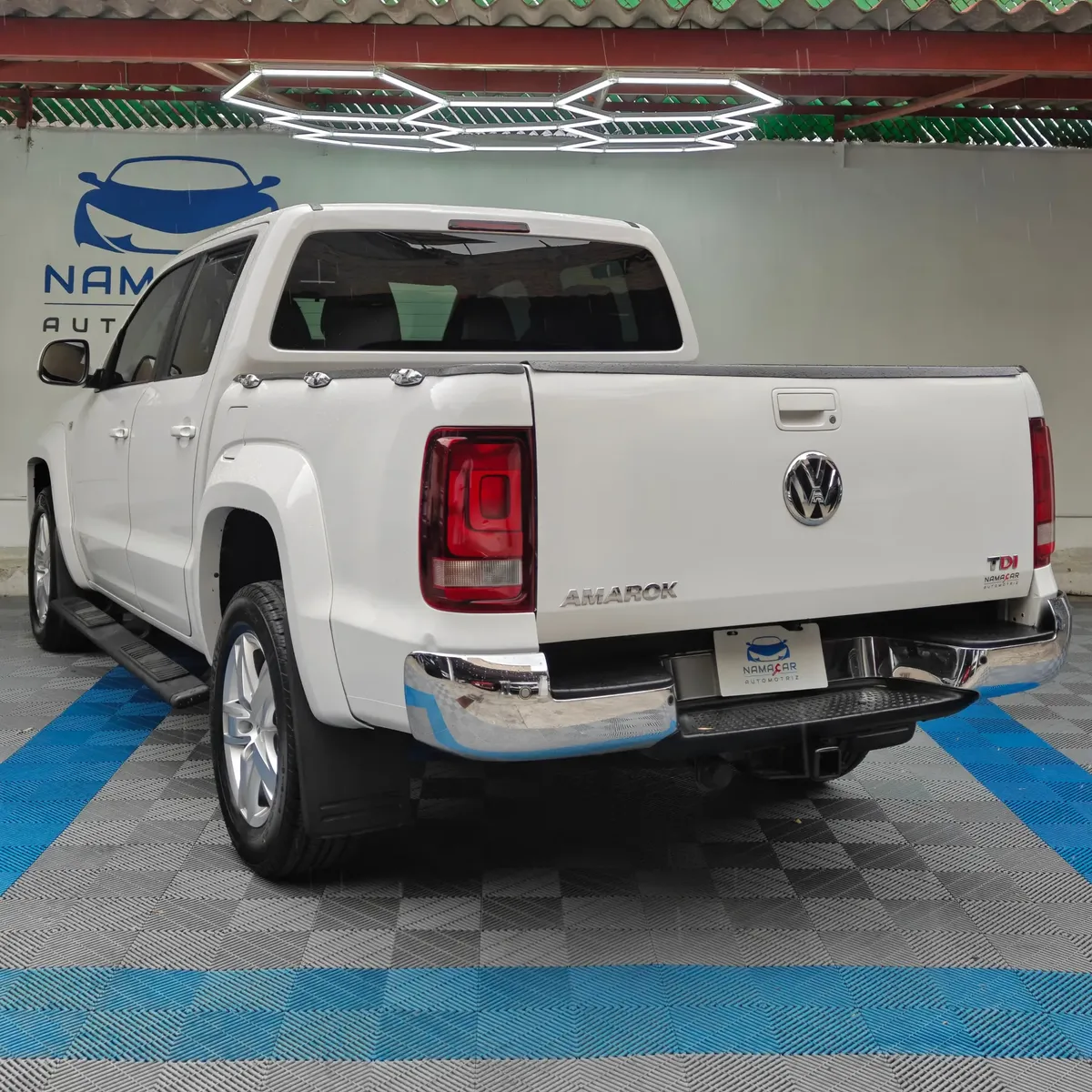 Camioneta pickup Volkswagen Amarok 2.0 Highline 4Motion automática año 2018 seminueva en color blanco, vista exterior trasera en ángulo de tres cuartos izquierda exhibida en Namacar Automotriz.