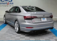 Auto sedán deportivo Volkswagen Jetta 2.0 GLI DSG automático año 2021 seminuevo en color gris plata, vista exterior trasera en ángulo de tres cuartos izquierda exhibido en Namacar Automotriz.