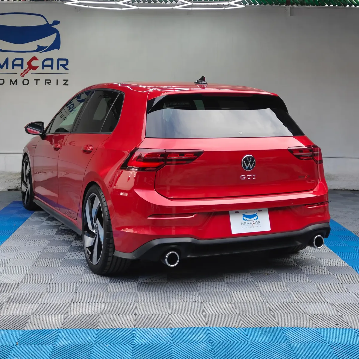 Hatchback deportivo Volkswagen Golf GTI 2.0 L de 241 HP automático DSG7 año 2024 seminuevo en color rojo brillante, vista exterior trasera en ángulo de tres cuartos izquierda exhibido en Namacar Automotriz.
