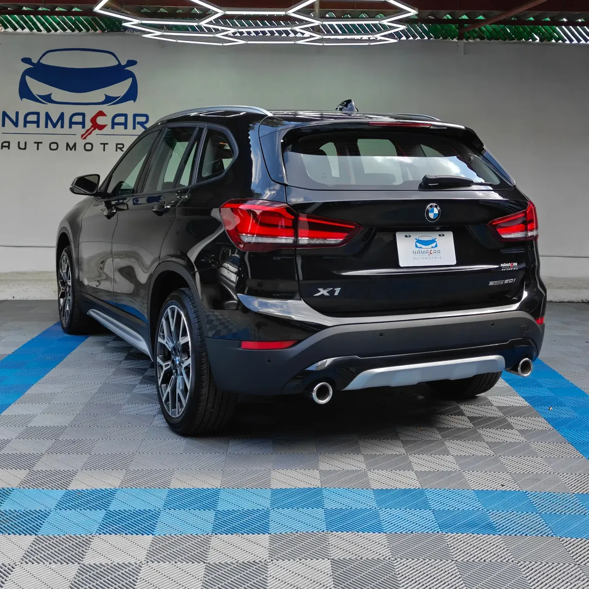 Camioneta SUV de lujo BMW X1 2.0 sDrive20i sDrive 20iA X Line transmisión automática año 2022 seminueva en color negro, vista exterior trasera en ángulo de tres cuartos izquierda exhibida en Namacar Automotriz.