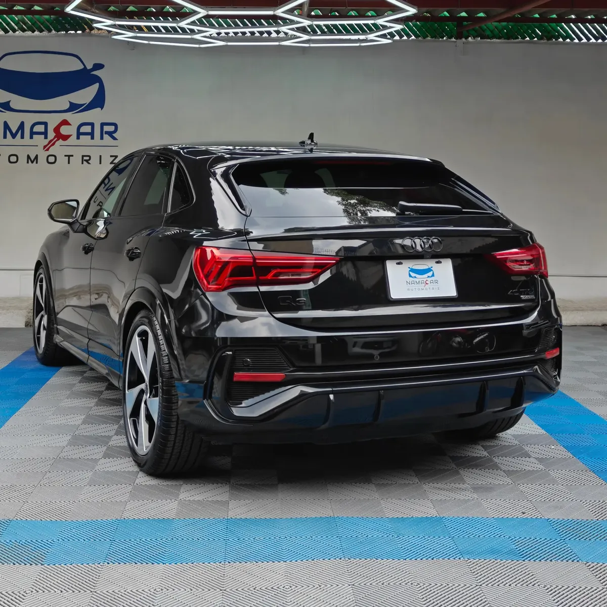 Camioneta SUV coupé de lujo Audi Q3 Sportback 2.0 S Line 180 Hp transmisión DSG automática año 2022 seminueva en color negro, vista exterior trasera en ángulo de tres cuartos izquierda exhibida en Namacar Automotriz.