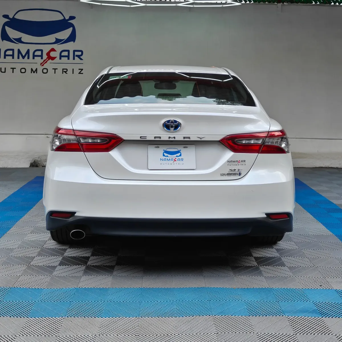 Auto sedán híbrido Toyota Camry 2.5 HEV XLE año 2024 seminuevo en color blanco, vista exterior trasera directa y completa exhibido en Namacar Automotriz.